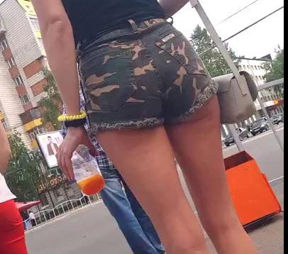 Girl in camo shorts walks around
